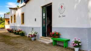 a building with a green door and flowers in pots at Albergue Vía Vitae in Otur