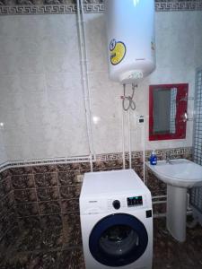 a bathroom with a washing machine and a sink at Fazenda guest house in Oktyabrʼskoye
