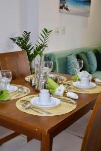 a wooden table with plates and glasses on it at VIP Beira Mar Residence in Fortaleza
