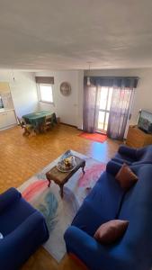 a living room with a blue couch and a table at Daboussi Home in Apúlia +2 photos