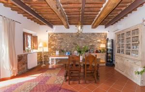 a kitchen with a table and chairs and a stone wall at B&B Toringo in Capannori