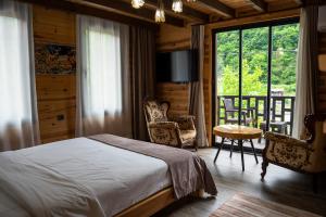 a bedroom with a bed and a table and chairs at Pallas Suit in Ardeşen