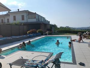 a group of people swimming in a swimming pool at Al Vicolo Uno in Montemagno