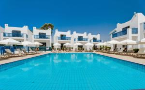 a swimming pool in front of a hotel at Kritamo Suites Sandy Bay in Ayia Napa