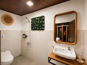 a bathroom with a toilet and a sink and a mirror at Purnama House Ubud in Ubud