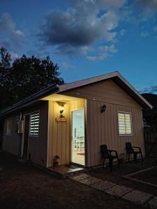 a small shed with a door and two chairs in front at Cabaña Rayantu Antuco in Antuco