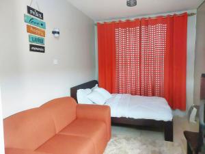 a bedroom with a bed and a orange chair at Reinastays in Kiambu +21 photos