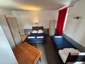 a small room with two beds and a table at Le grand cerf Blain in Blain