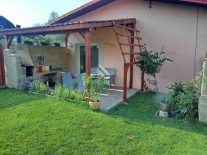 a backyard with a wooden pergola next to a house at Bungalov Mikulášovice in Mikulášovice