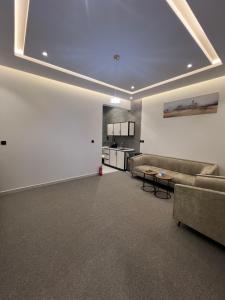 a living room with couches and a table and a kitchen at شقق فاخرة in Mahlal