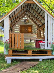 a wooden pergola with a bench in the grass at Zacisze Pod Reglami & Sauna in Zakopane