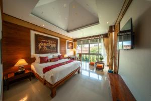 a bedroom with a large bed and a large window at Kodchasri Thani Heritage Collections in Chiang Mai +136 photos