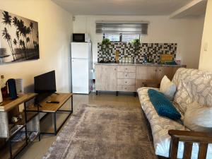 a living room with a couch and a kitchen at Seaview Sunsets in Gqeberha