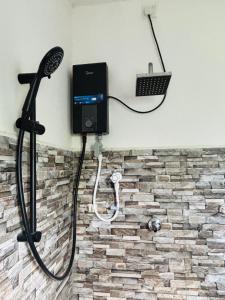 a shower in a bathroom with a hair dryer at Tropical Point Inn in Matara