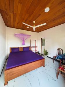 a bed in a room with a wooden ceiling at Tropical Point Inn in Matara