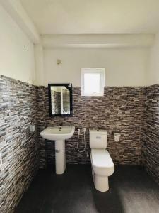 a bathroom with a white toilet and a sink at Tropical Point Inn in Matara +12 photos