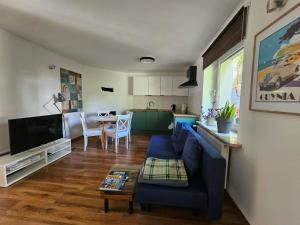 a living room with a blue couch and a table at Oaza Spokoju in Gdynia