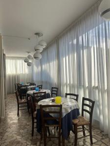a dining room with tables and chairs and curtains at Hotel Trocadero - Koolibry Hotels in Cervia +34 photos
