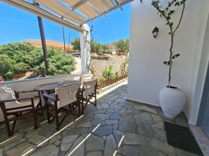 a patio with a table and chairs and a window at Kini Bay in Kini