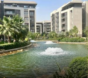 a pool of water in front of some buildings at دقيقه للبحيره أقامه فندقيه مدينتي بريفادو madinaty privado in Madinaty