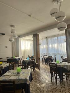 a restaurant with tables and chairs and a large mirror at Hotel Trocadero - Koolibry Hotels in Cervia