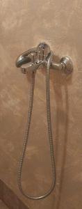 a shower head with a hose on a wall at Sea View Garden in Poros +1 photo