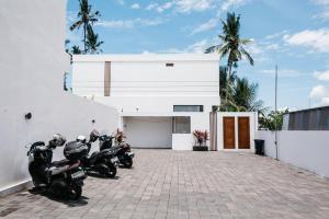 a group of motorcycles parked next to a white building at Santara Villa Ubud in Ubud