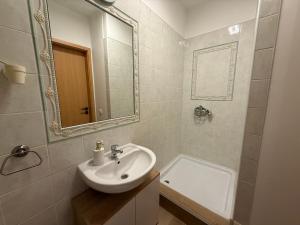 a white bathroom with a sink and a mirror at Heaven SPA Eger in Eger