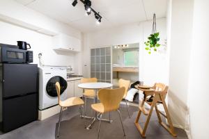 a kitchen with a table and chairs in a room at Epilogue Hotel 202 in Fukuoka