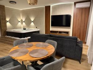 a living room with a table and a couch and a television at Heaven SPA Eger in Eger