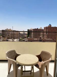 a table and chairs on a balcony with a view at 3pyramids view inn in Cairo