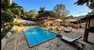a pool with chairs and umbrellas in a yard at Pousada Oceanica Buzios in Búzios +30 photos