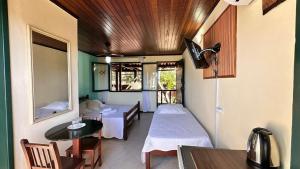 a room with a bed and a table and a room with a bed at Pousada Oceanica Buzios in Búzios
