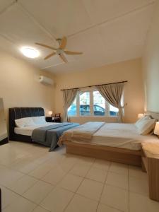 a bedroom with two beds and a ceiling fan at Melaka Beach Villa C Type in Malacca +65 photos