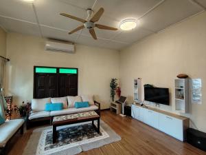 a living room with a couch and a ceiling fan at Melaka Beach Villa C Type in Malacca
