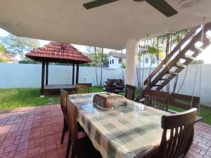 a table and chairs on a patio with a grill at Melaka Beach Villa C Type in Malacca