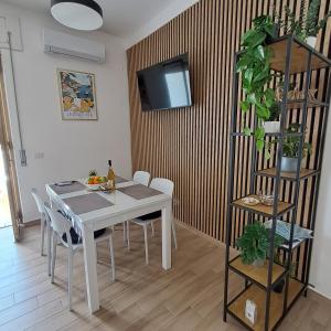 a dining room with a white table and chairs at Bella Italia in Marina di Strongoli