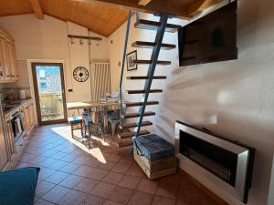 a living room with a spiral staircase and a fireplace at Cèsa MeSa in Canazei