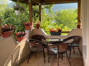 a balcony with a table and chairs and flowers at Unique Una in Ripač