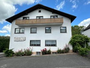 a white building with a balcony on top of it at Zum Lahnfelsen Gräveneck in Gräveneck