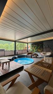 a large patio with a swimming pool with a large ceiling at Uzungol Ada Bungalow in Uzungöl