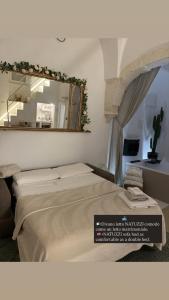 a bedroom with a large bed and a mirror at BELLE HOME OSTUNI vasca vista mare in Ostuni