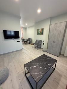 a living room with a table and a flat screen tv at Casa de Greta in Svityazʼ