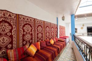 a living room with a long couch against a wall at Hotel Nisrine in Chefchaouen
