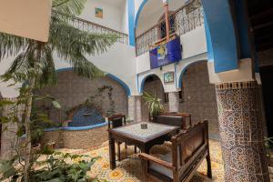 a room with a table and chairs in a building at Hotel Nisrine in Chefchaouen