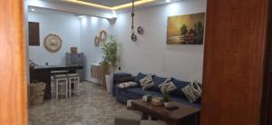 a living room with a blue couch and a table at Padova Surf Hous in Imsouane