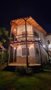 a white house with lights on the side of it at Acalanto do Sargi in Uruçuca