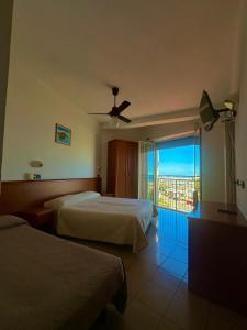 a hotel room with two beds and a balcony at Hotel Trocadero - Koolibry Hotels in Cervia