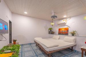 a room with a bed and a tv in it at Flora Ecostay Resort and Spa Lonavala in Lonavala