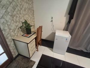 a small room with a table and a refrigerator at Casa da Dôdi in São Joaquim